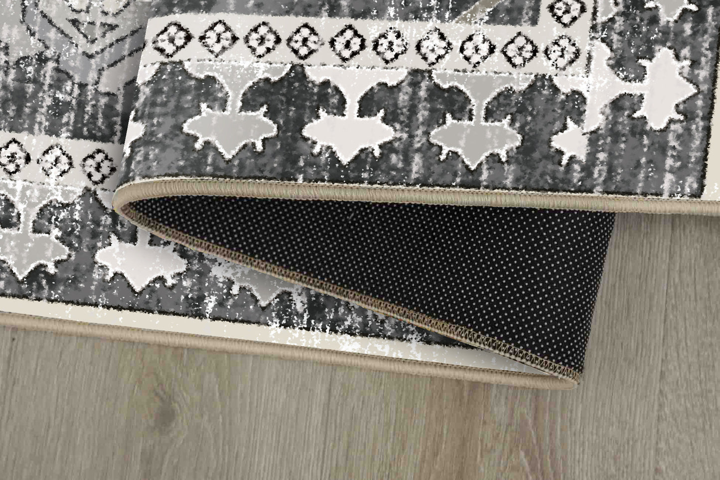 Horizon Charcoal Damask rug corner folded, showing the non-slip dot backing