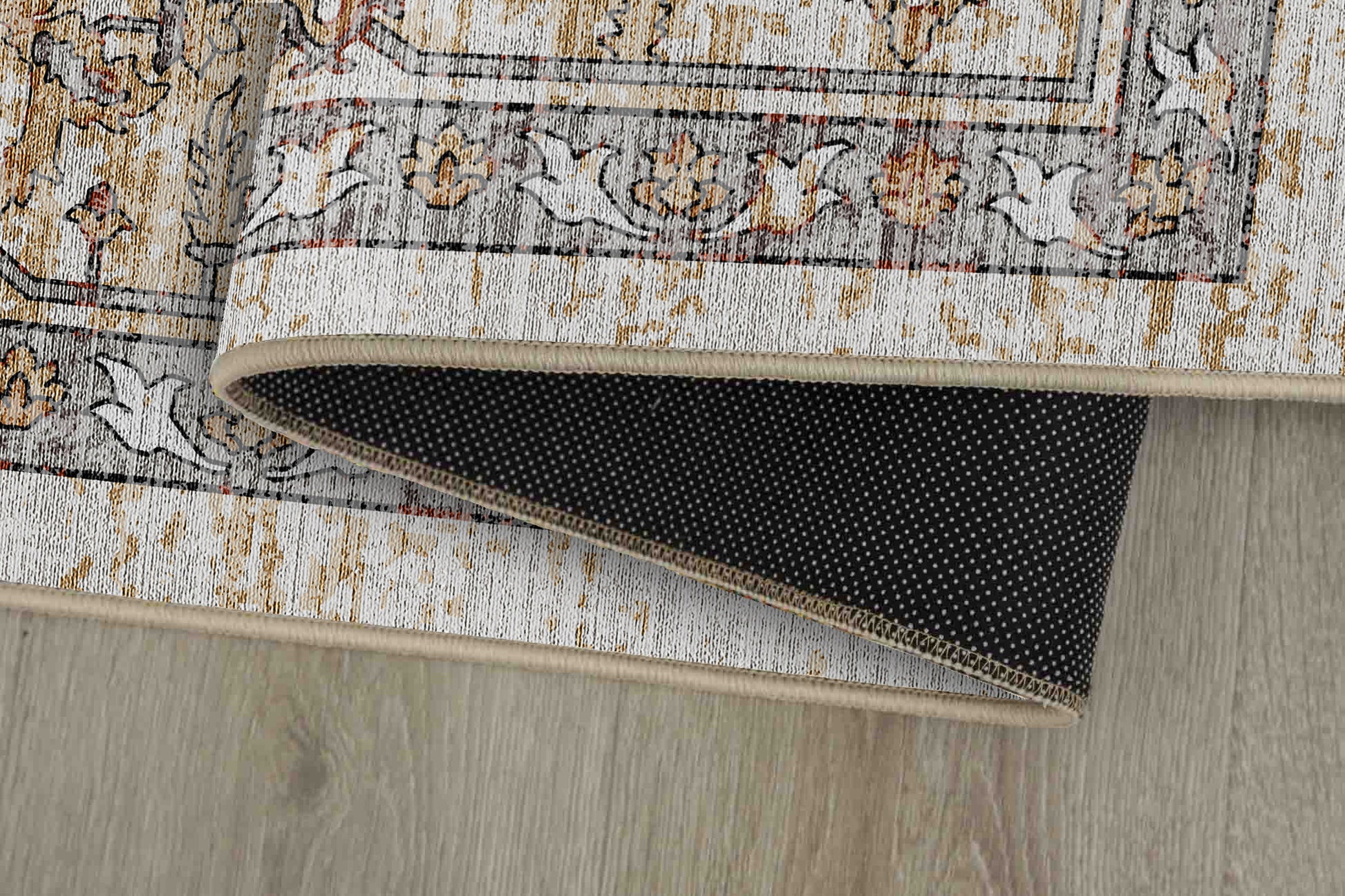 Sabrina Faded Gold rug corner folded, showing the non-slip dot backing