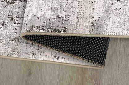 Torino Stone Border rug corner folded, showing the non-slip dot backing